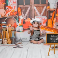 Welcome to the 'Little Chef's Kitchen'. This theme is all about fun and capturing candid moments as your baby plays with safe props like flour and toy food in a custom-designed kitchen backdrop.