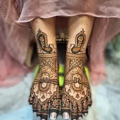 An elegant feet mehendi design with graceful peacock motifs and delicate hanging bells, creating a look of timeless beauty.