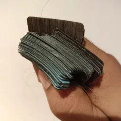 This close-up shot shows a bundle of tape-in extensions ready for application. You can see the thin and discreet tape tabs that lie flat against the head for an undetectable finish.