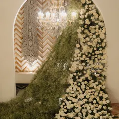 A unique floral installation where a cascade of baby's breath and white chrysanthemums flows through an archway. This is an example of the artistic and unexpected decor elements I love to create.