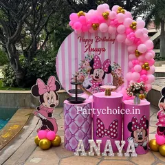 A stylish Minnie Mouse decoration set against a beautiful poolside backdrop. The pink and gold color scheme, complete with a balloon arch and character cutouts, adds a touch of glamour to the party.