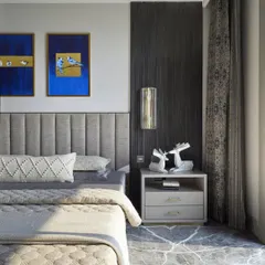 A pair of my bird paintings, 'Nabhah', meaning 'surrounded by clouds', in a serene master bedroom. The deep blue background and gold leaf highlight the delicate forms of the blue jays, creating a sense of tranquil elegance.