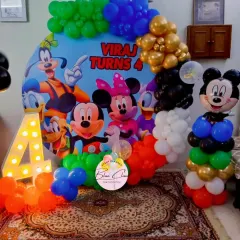A classic Mickey Mouse Clubhouse theme for a 4th birthday party. This decoration features a large character backdrop, a marquee number '4', and a fun Mickey Mouse balloon sculpture.