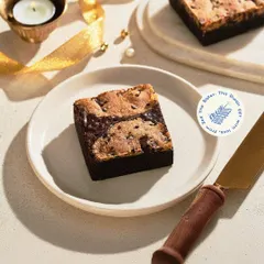 Our Cookie Dough Brownie is a festive favorite. This decadent treat, featuring a fudgy brownie base topped with crunchy cookie crumble, was a highlight of my Diwali gift collection.