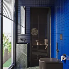 A render for a guest bathroom in a Kolkata home, featuring bold cobalt blue tiles, dark green marble floors, and matte black fixtures for a modern and impactful look.