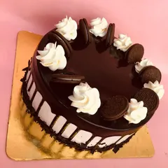 Our eggless Oreo cake is perfect for cookie lovers. It's decorated with a glossy chocolate glaze, whipped cream swirls, and whole Oreo cookies.