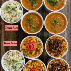 A variety of rice dishes and curries from my kitchen. This includes classic Jeera Rice, Veggie Biryani, Tawa Pulao, and a rich Pav Bhaji, showing the range of meals I prepare.