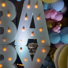 This whimsical baby shower featured large marquee letters, teddy bears nestled in pastel balloon clouds, and a custom hot air balloon prop, creating a dreamy and joyful atmosphere.