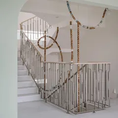 The clean lines of the staircase and railing at Eden House provide the perfect canvas for the organic, flowing form of the LUNA light installation. It's a beautiful example of balance in design.