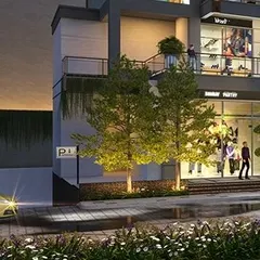 A close-up evening shot showing the interaction of light, landscape, and architecture. Uplighting on the trees and soft light from the retail interiors create a warm and inviting ambiance for visitors.