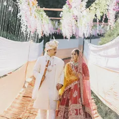 A candid shot of the newly married couple walking hand-in-hand across a beautifully decorated bridge. These natural, in-between moments often make the most romantic wedding photos.