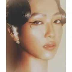 A soft, ethereal beauty close-up. The glowing light, flawless skin, and unique graphic eyeliner showcase a more artistic and delicate approach to beauty photography.