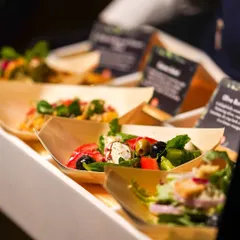 A variety of fresh salads served in individual, eco-friendly wooden boats for easy mingling.