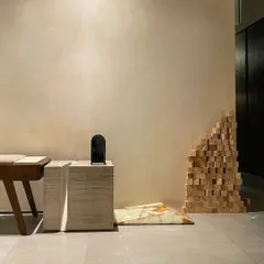 This detail shot from our studio highlights the dialogue between art and architecture. The minimalist space acts as a gallery for sculptural furniture and unique material applications, like the onyx marble accent on the floor.