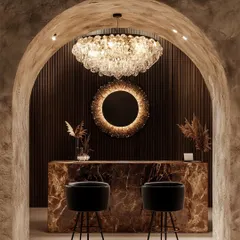 A classic tiered crystal chandelier brings timeless opulence to this space. Paired with a modern sunburst mirror, it demonstrates how I blend classic and contemporary elements to create a rich, sophisticated interior.