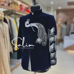 A mannequin displaying a navy blue velvet Jodhpuri jacket with a silver embroidered peacock. The design is elegant and symbolic, perfect for a wedding ceremony.