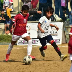 A player skillfully dribbles past a defender. This highlights the technical ability and confidence we instill in our attackers.