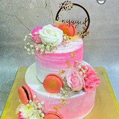 A stunning two-tier engagement cake in shades of pink. I decorated this one with fresh flowers and delicate macarons for an extra touch of elegance.