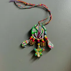 This is an exquisite Lumba I made for the Rakhi season. It's crafted from clay and decorated with wooden beads, delicate butterfly embellishments, and a real pearl.