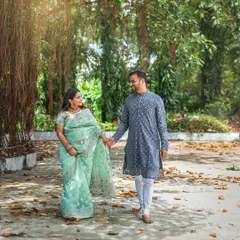 A gentle stroll hand-in-hand, with the sea-green saree complementing the natural surroundings. This outdoor session shows how traditional wear can look beautifully fresh and modern against an open, airy backdrop.