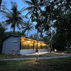 The communal area of a hostel in Chikmagalur, beautifully lit up at dusk. It's a wonderful place to meet fellow travelers, share stories, and relax under the stars after a day of hiking and exploring the coffee plantations.
