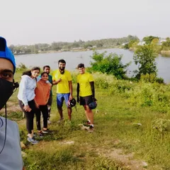 A selfie capturing the group's excitement to be riding together again. The lake and greenery make for a perfect backdrop.