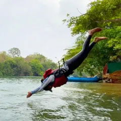 Sometimes the best part of the adventure is the pure, unscripted fun. Here, a participant takes a joyful leap into the cool waters of the Kali River during a break in our Dandeli rafting and kayaking course.