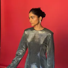 The model posing against the red paper background. This BTS shot gives a sense of the studio environment and the lighting setup we used.