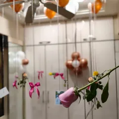 A really personal touch is to hang photos from the balloons. Here, I attached pictures and single pink roses to the ribbons of helium balloons, letting them float above the bed and around the room as a sweet surprise.