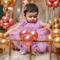 Another shot from Yasmeen's first birthday party, showing her interacting with the balloon decorations. These little moments of discovery are what make kids' party photography so special.