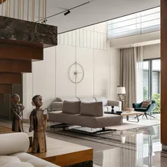 A view of the sculptural staircase at Villa Shakthi, which ascends from a marble plinth. This element is not just for circulation; it is a central feature that connects the home's levels and showcases our philosophy of integrating dramatic, functional art into our designs.