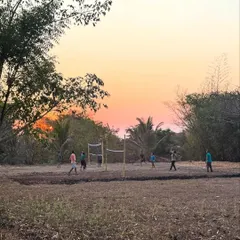 The sunset paints the sky with warmth as evening settles over the ashram. These quiet moments of reflection by the river or among the trees are a cherished part of the daily rhythm here.