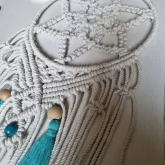 This close-up shows the combination of different knots I use to create the web of the dreamcatcher, a testament to the patient artistry of macrame.
