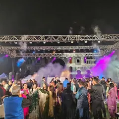 A view from my perspective, watching a full dance floor at an outdoor sangeet. The combination of fog effects and dynamic lighting helps create an electric atmosphere for guests.