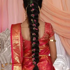 A classic South Indian braid for a puberty ceremony. I used delicate pink floral accessories along the length of the braid to match her beautiful red and gold saree.