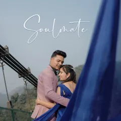 A dramatic "soulmate" portrait on a suspension bridge, with the flowing blue fabric creating a stunning visual against the mountain backdrop.