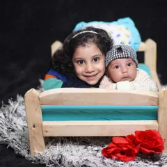 A heartwarming photo of an older sister with her newborn sibling. I focus on capturing these natural, unposed moments of bonding.