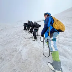 Roped up and ready to go. A team of trekkers making their way up a steep snow slope on the Friendship Peak expedition.