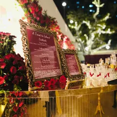 A beautiful evening shot of our gilded bar setup, adorned with red roses and ornate, custom-framed menus. The warm lighting and reflections on the mirrored surface created an inviting and glamorous focal point for the celebration.