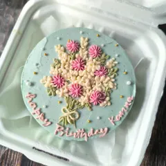 A bouquet you can eat. This birthday bento cake is decorated with an intricate bouquet of piped buttercream flowers in soft pink and white on a lovely pastel blue base.