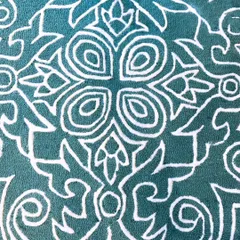 A close-up of a textured carpet featuring a bold, modern interpretation of a classic medallion pattern. The contrast between the raised white lines and the deep teal looped pile creates a dramatic and stylish look.
