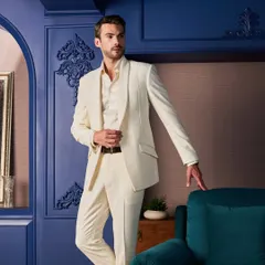 An all-ivory tuxedo offers a fresh and regal alternative to traditional black. This piece features subtle, intricate hand-embroidery with small pearls and beads on the lapel, perfect for a day wedding or a themed celebration.