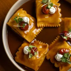 A dish of pure comfort. This is our slow-cooked lamb and potato doppio agnolotti, a double-stuffed pasta bathed in a rich lamb jus. Dollops of goat’s cheese and blistered tomatoes cut through the richness.