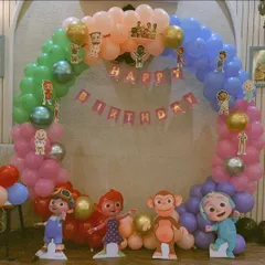 A Cocomelon themed ring backdrop decorated with pastel balloons and cutouts of JJ and his friends, perfect for a birthday photo booth.