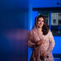 A lovely shot against a cool blue background. The contrast makes her soft pink outfit and glowing makeup pop, showcasing her beautiful smile.