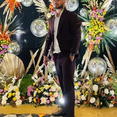 Posing against a festive backdrop, perfect for a sangeet or reception. I bring a professional yet fun presence to your wedding events.