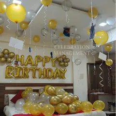 We add a personal touch to this birthday surprise by hanging photos from the ceiling balloons. It's a wonderful way to celebrate memories while creating new ones, all within a festive gold and silver theme.