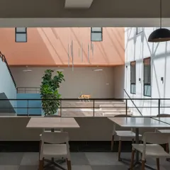 The interior of the Nirbhaya Centre is organized around a central, light-filled atrium with a grand staircase, designed to be an uplifting and non-intimidating space.