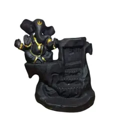A small resin statue of Lord Ganesha designed as a backflow incense burner. The smoke cascades down the sculpted waterfall, creating a serene effect.