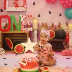 The happiest little girl enjoying her watermelon-themed first birthday! I love her expression here as she enjoys a slice of fresh watermelon alongside her beautiful cake.